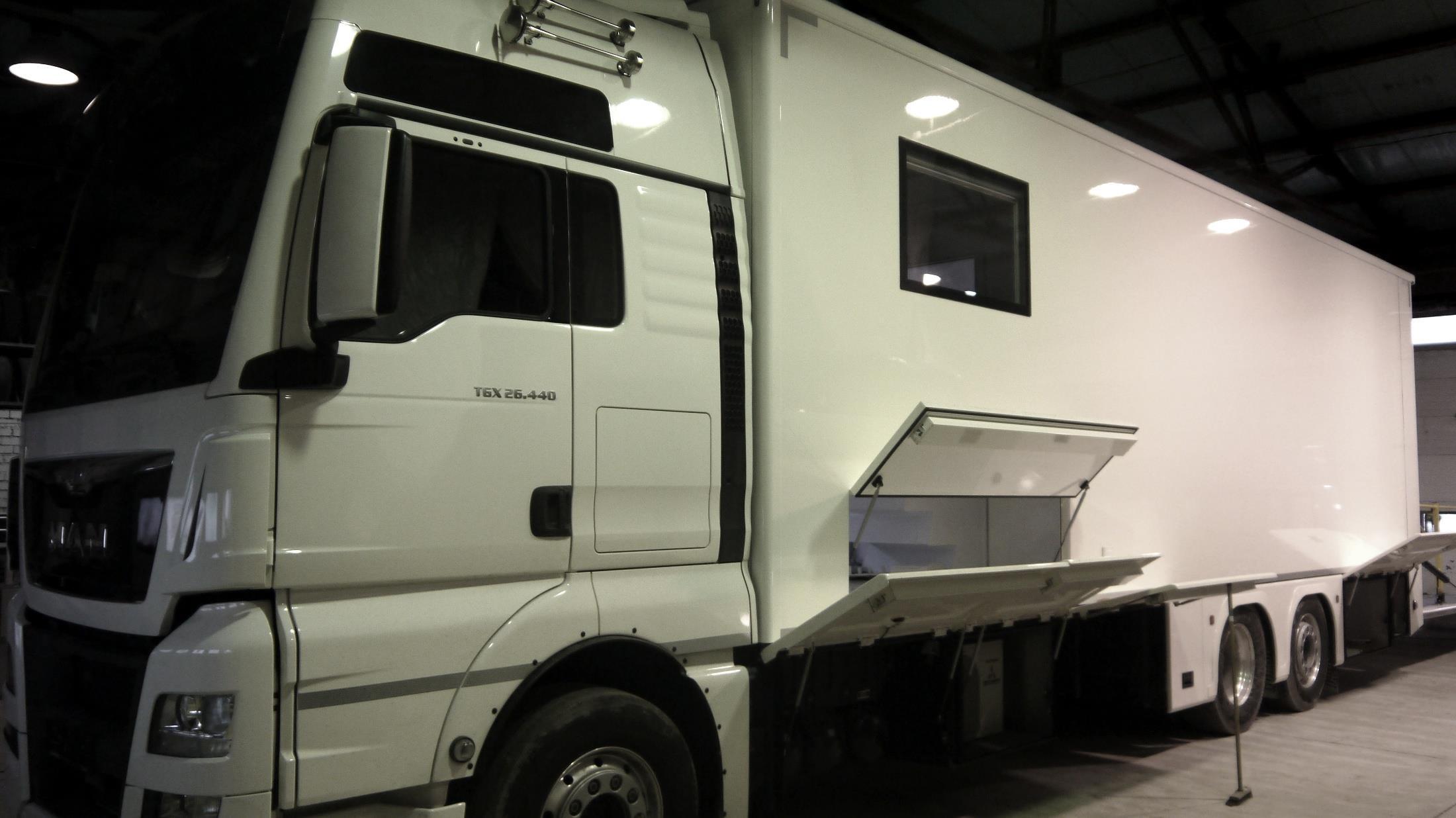 MAN TGX 26.440 race transporter with garage box open