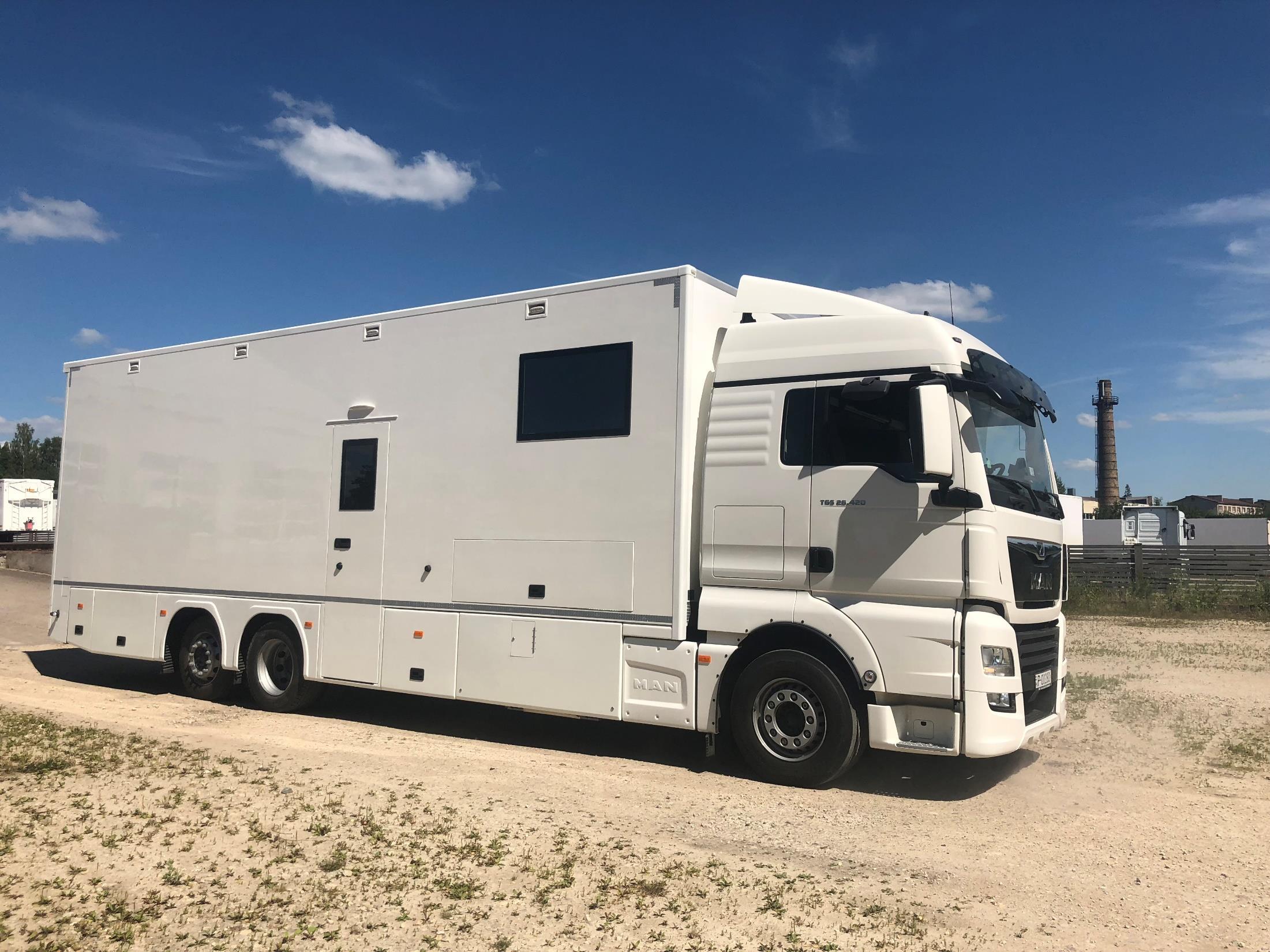 MAN TGS 26.520 race transporter parked on gravel